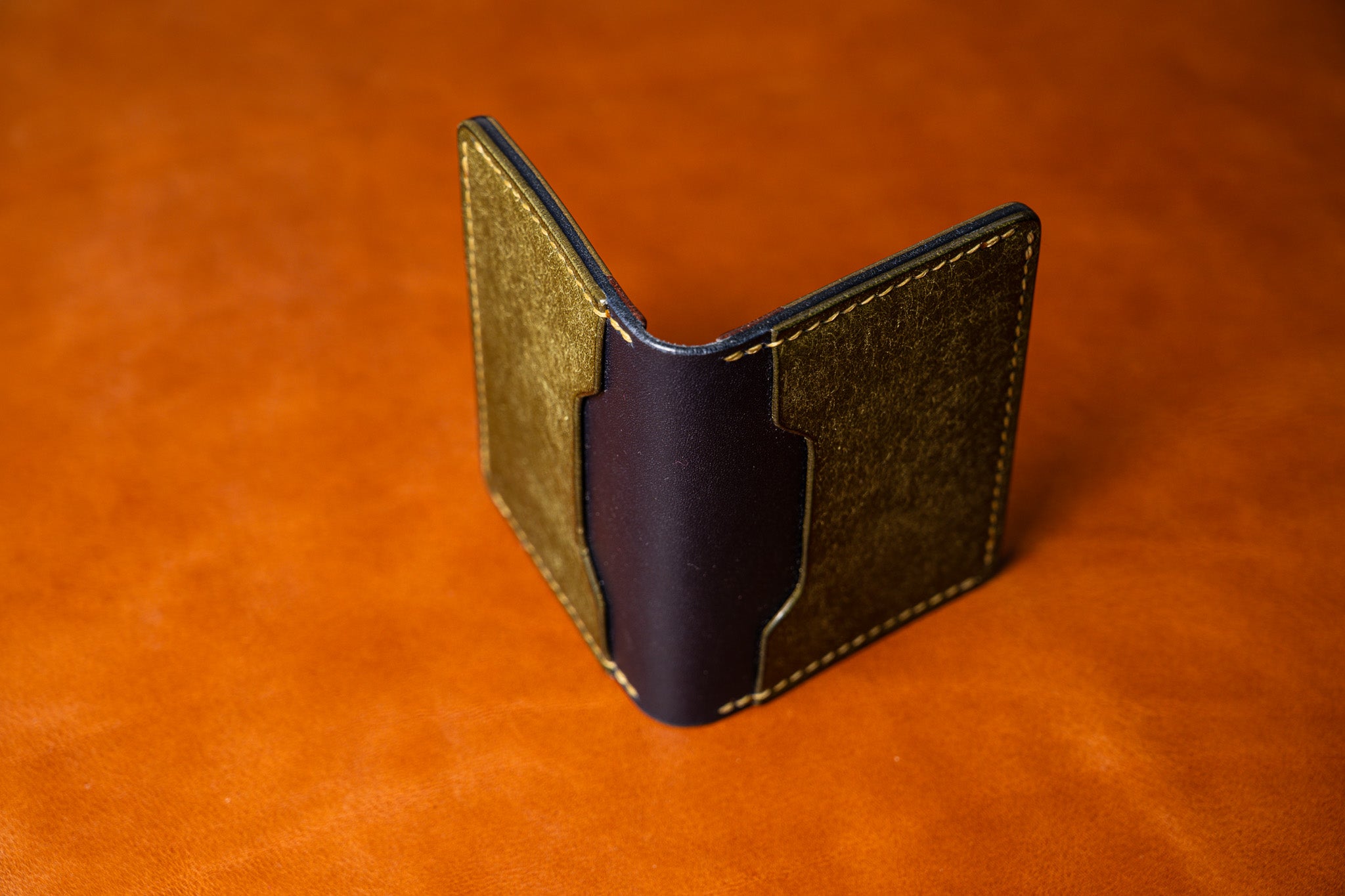 Two-tone leather wallet on an orange background