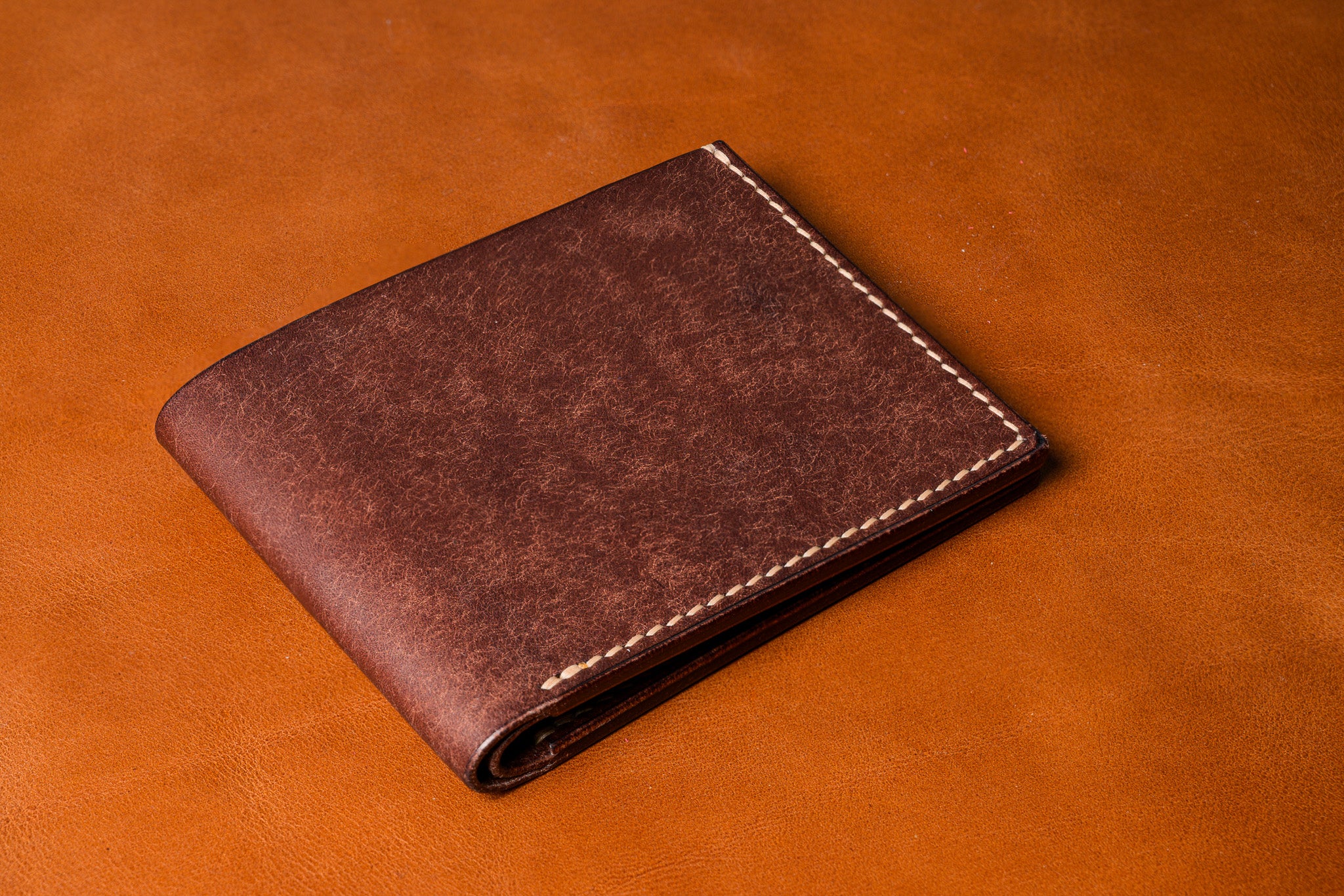 Brown leather wallet on a matching brown background