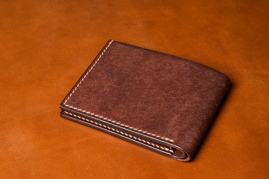 Brown leather wallet on a matching brown background