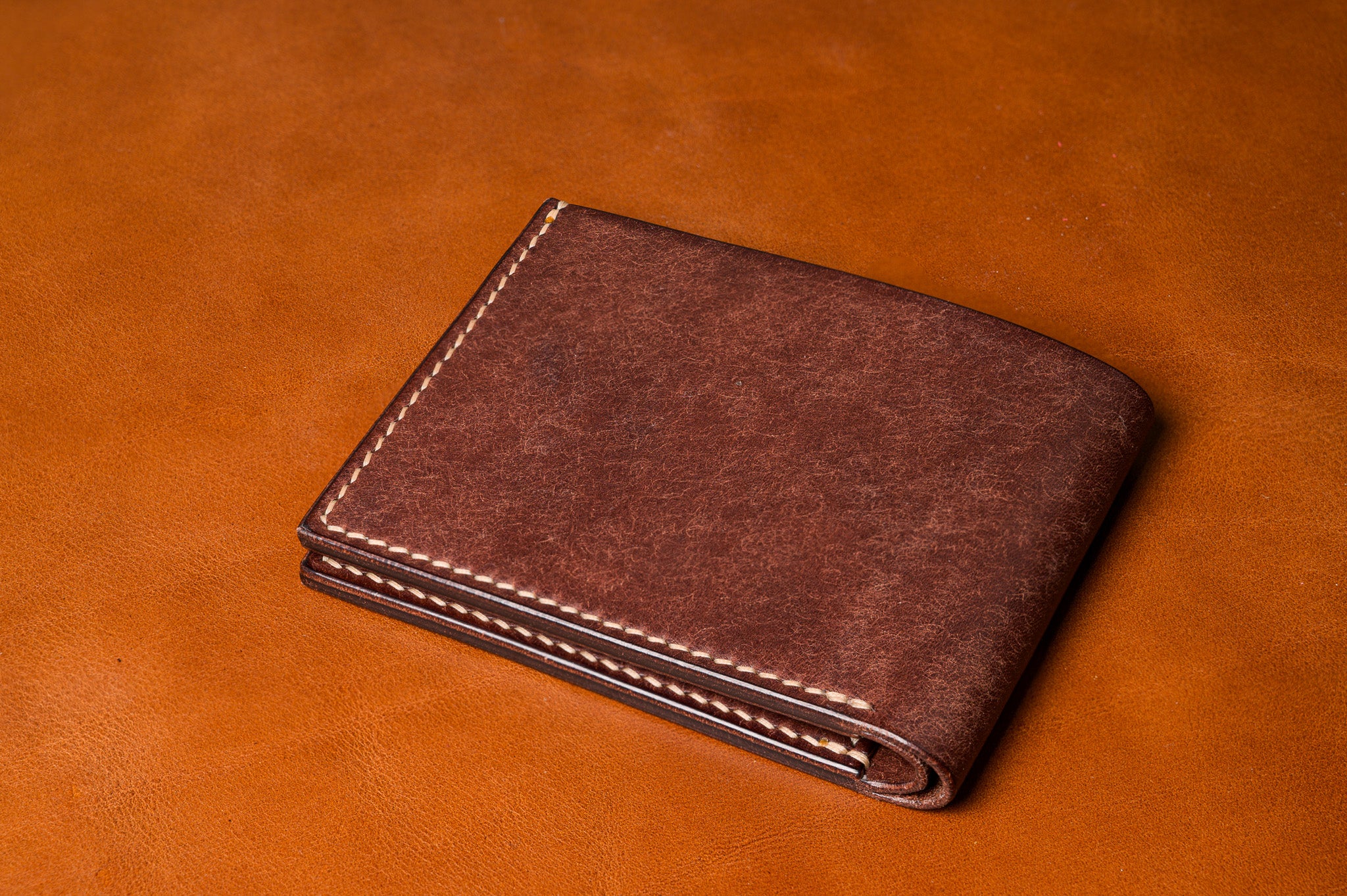 Brown leather wallet on a matching brown background