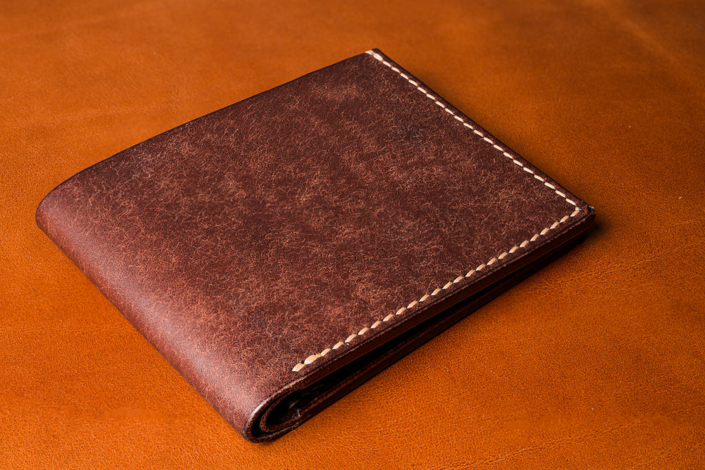 Brown leather wallet on a matching brown background