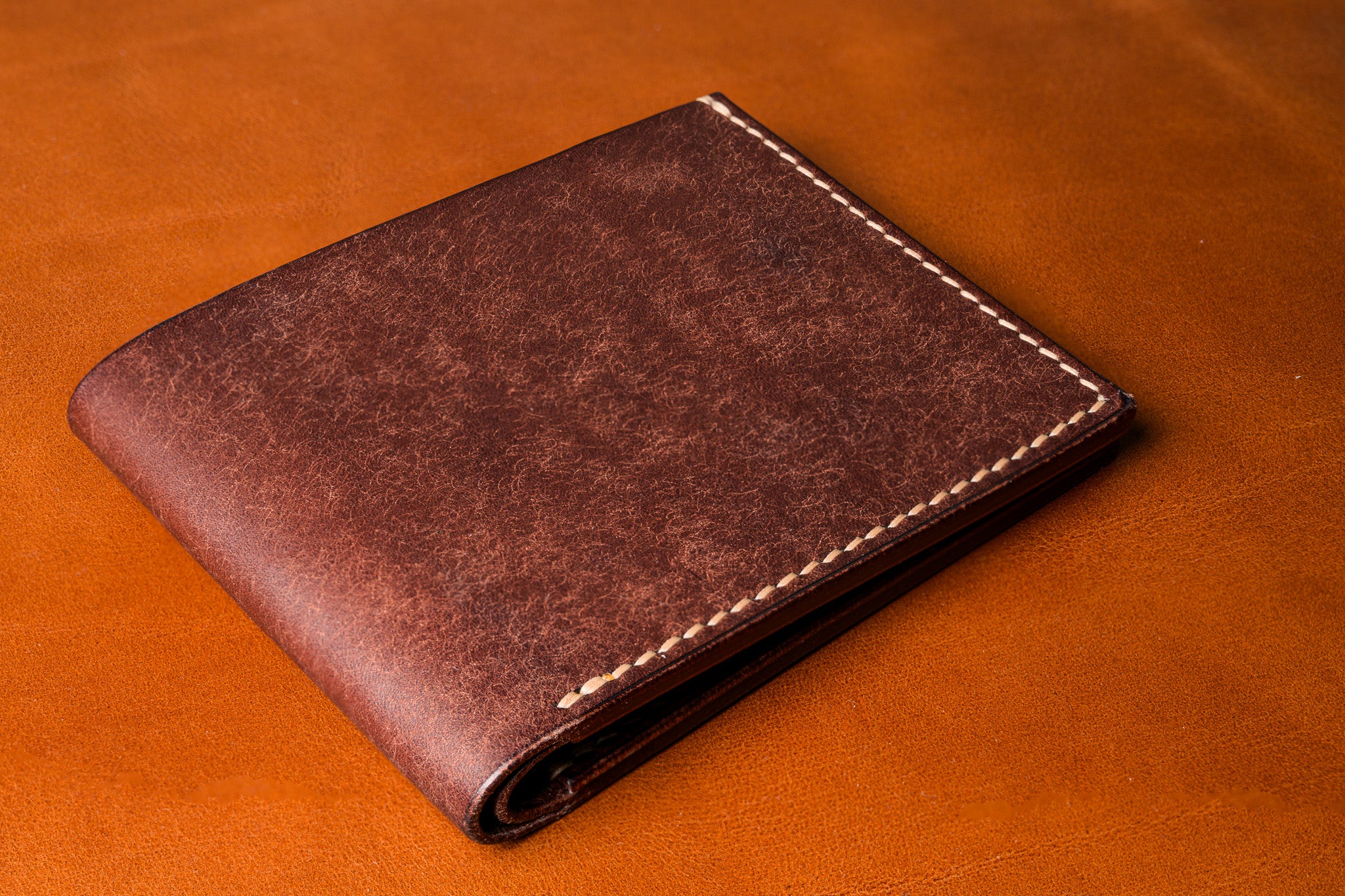 Brown leather wallet on a matching brown background