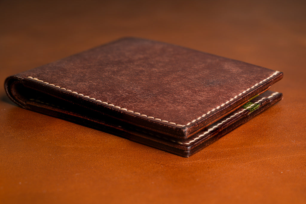 Brown leather wallet on a matching brown background