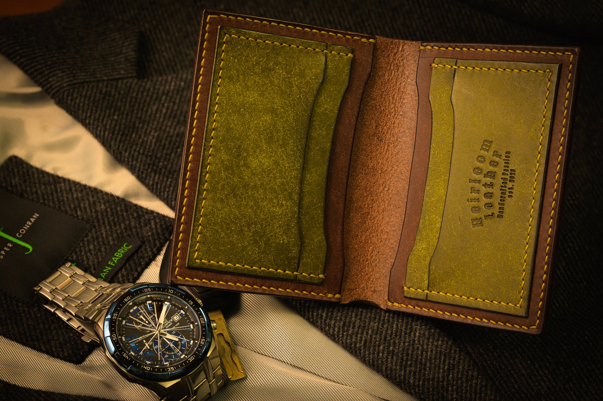 Brown leather wallet with green interior and visible brand name on a textured surface.
