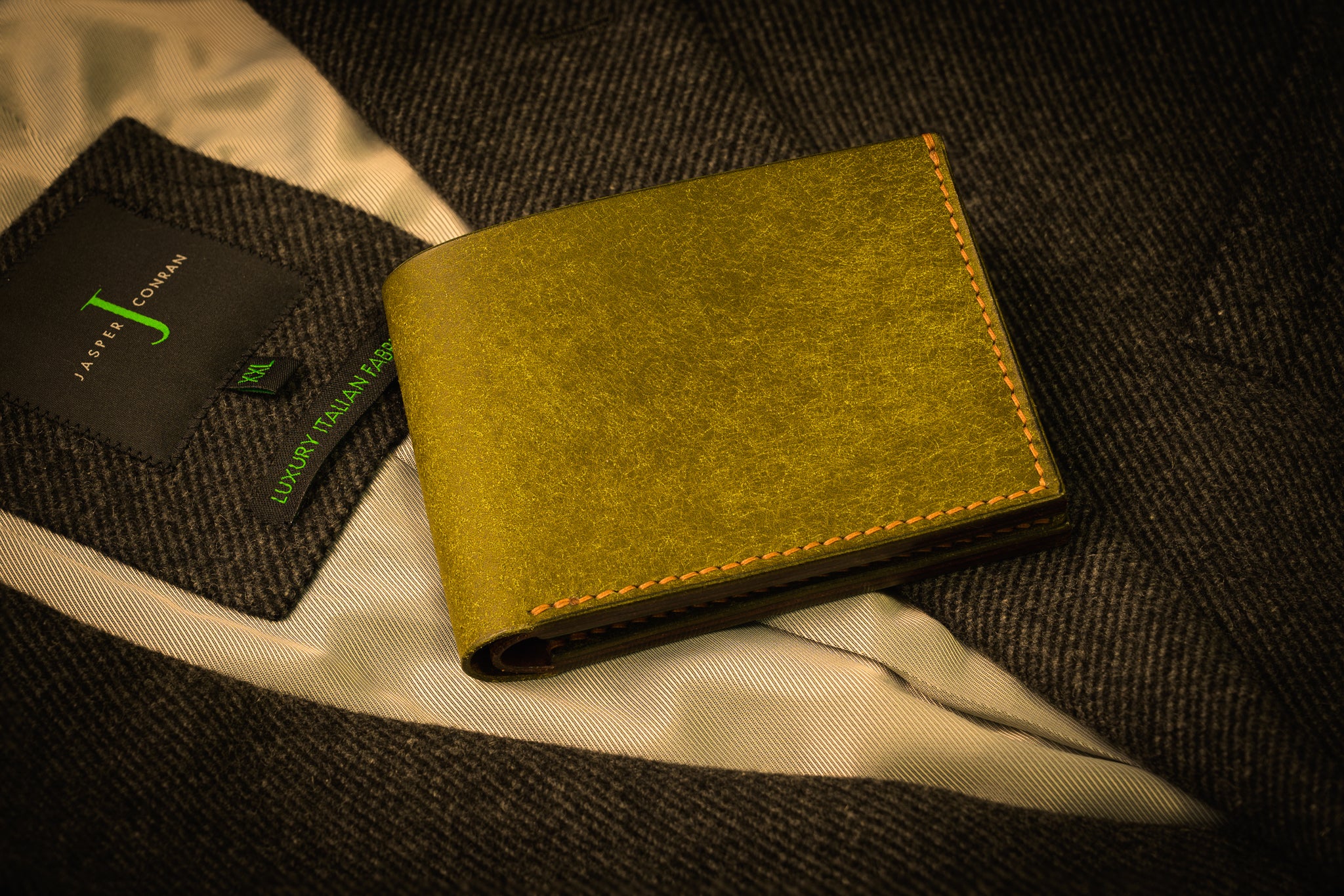 Green wallet on a textured surface with a brand card in the background