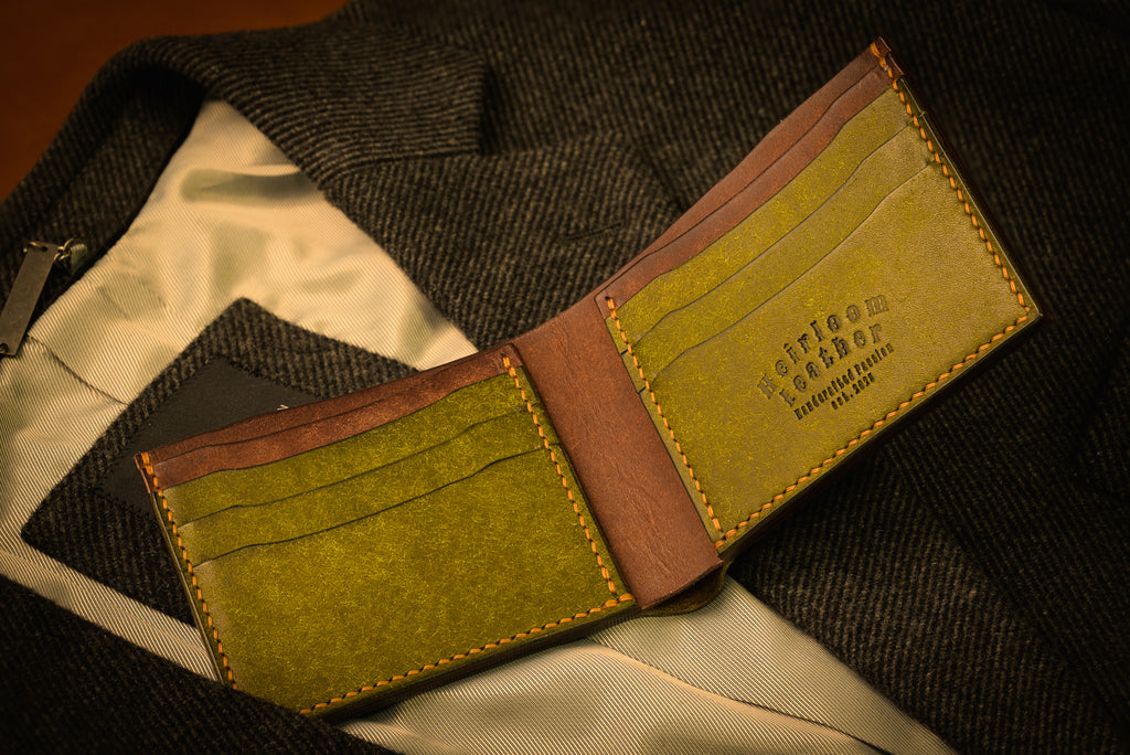 Green and brown leather wallet on a textured surface
