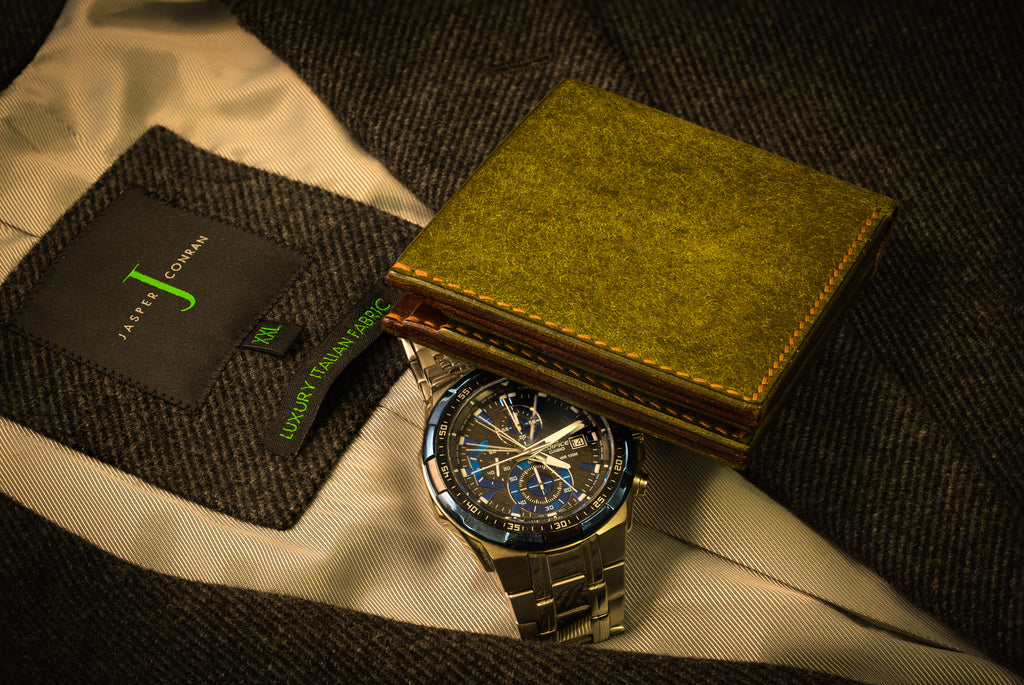 Gold watch with a textured green box on a textured surface