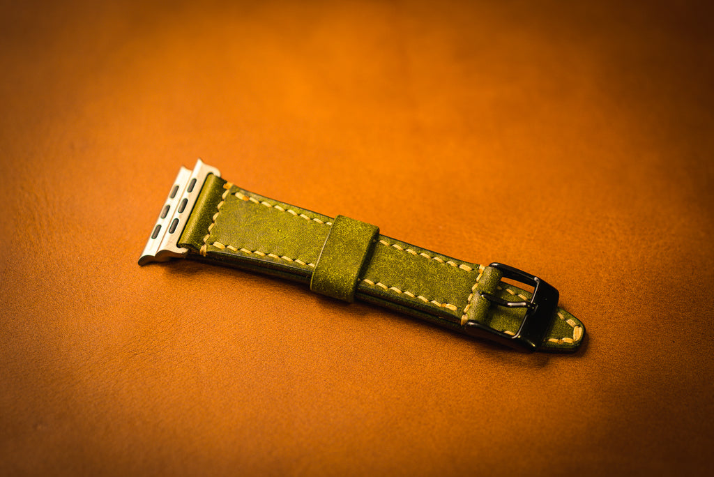 Olive watch strap on a brown background