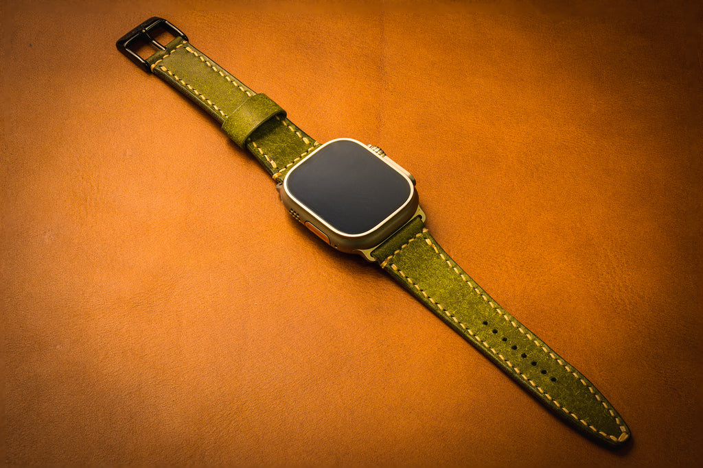 Smartwatch with a green leather strap on an brown background