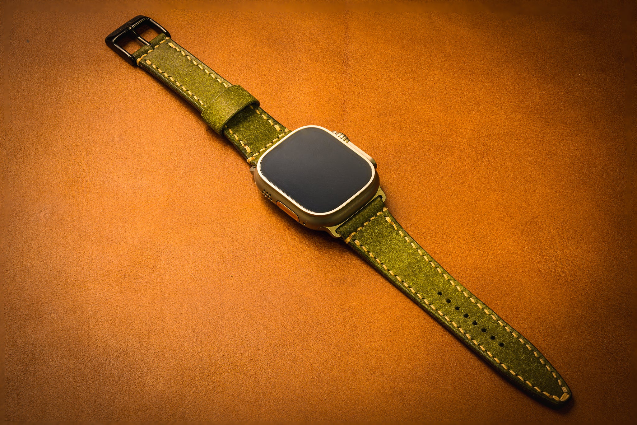 Smartwatch with a green leather strap on an brown background