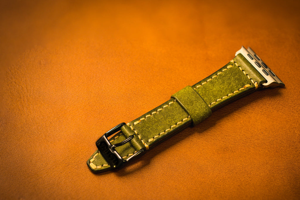 Green leather watch strap on an brown background