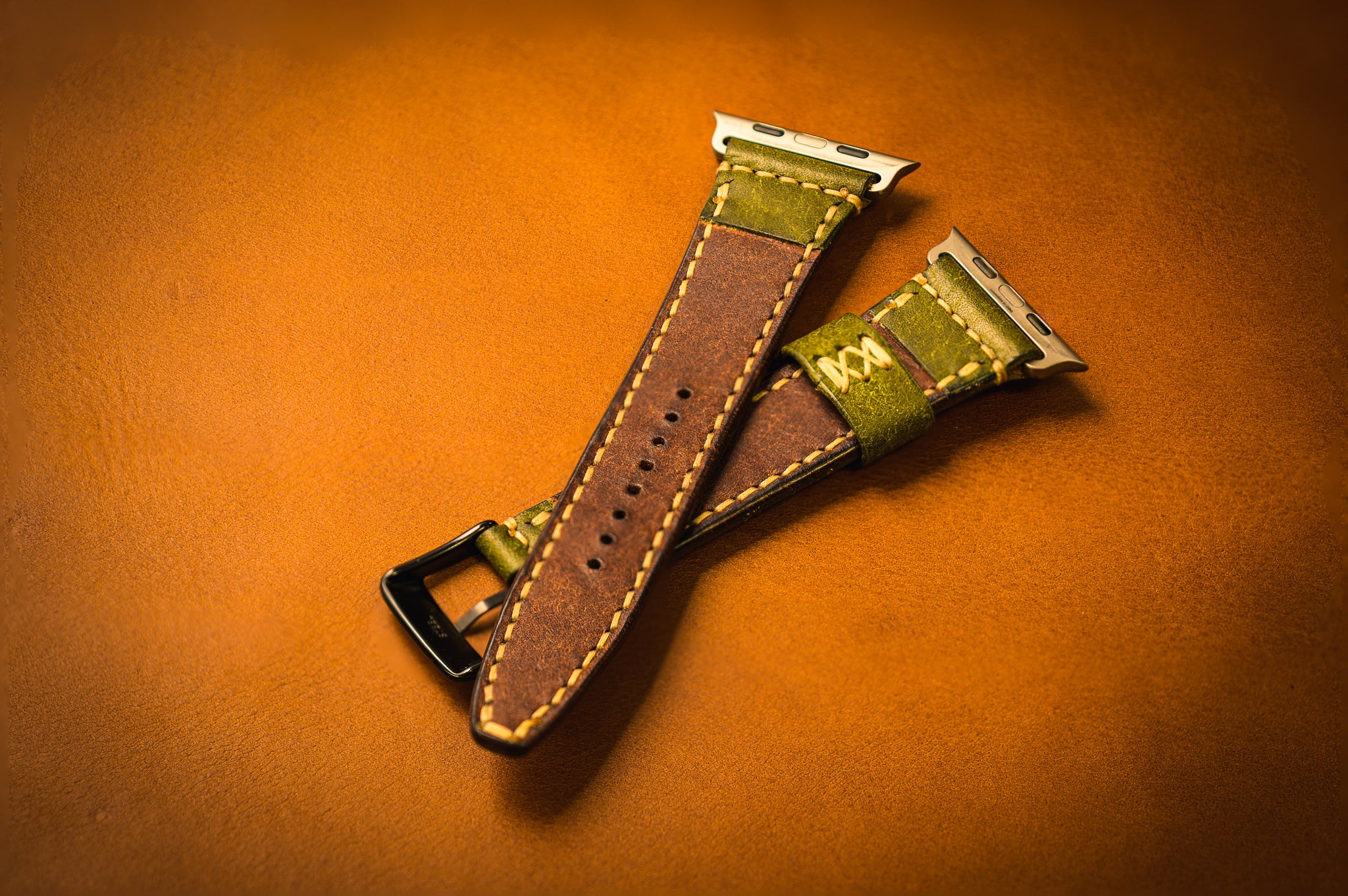 Two leather watch straps on an brown background